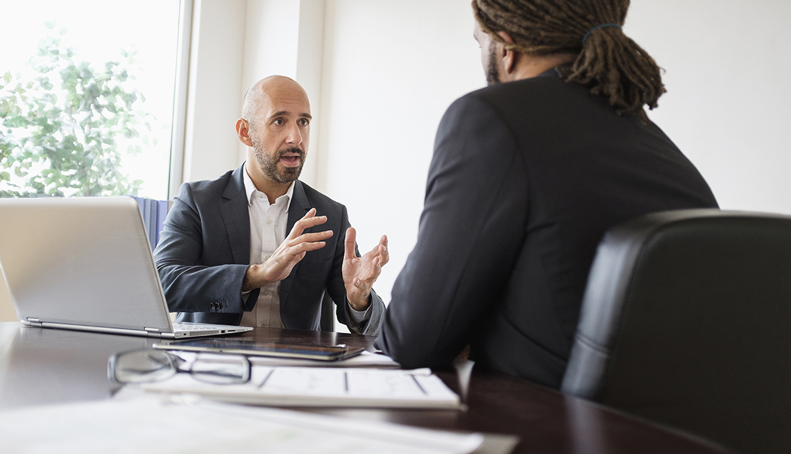 Two businessmen having discussion at desk in office